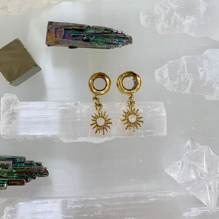 three pairs of earrings sitting on top of ice