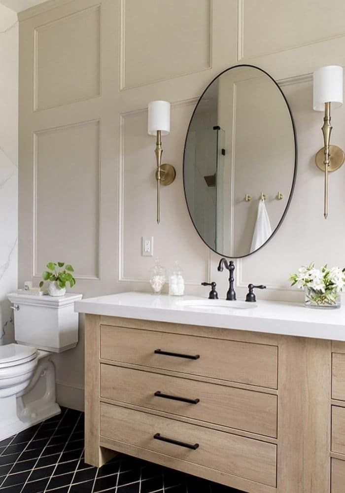 a bathroom with two sinks, a toilet and a large mirror on the wall above it