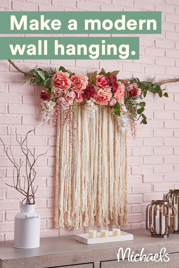 a pink brick wall with flowers hanging from it's side and candles on the table