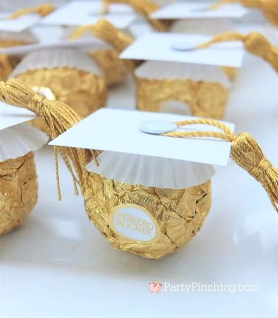 graduation caps and tassels are on top of cupcakes in gold foil