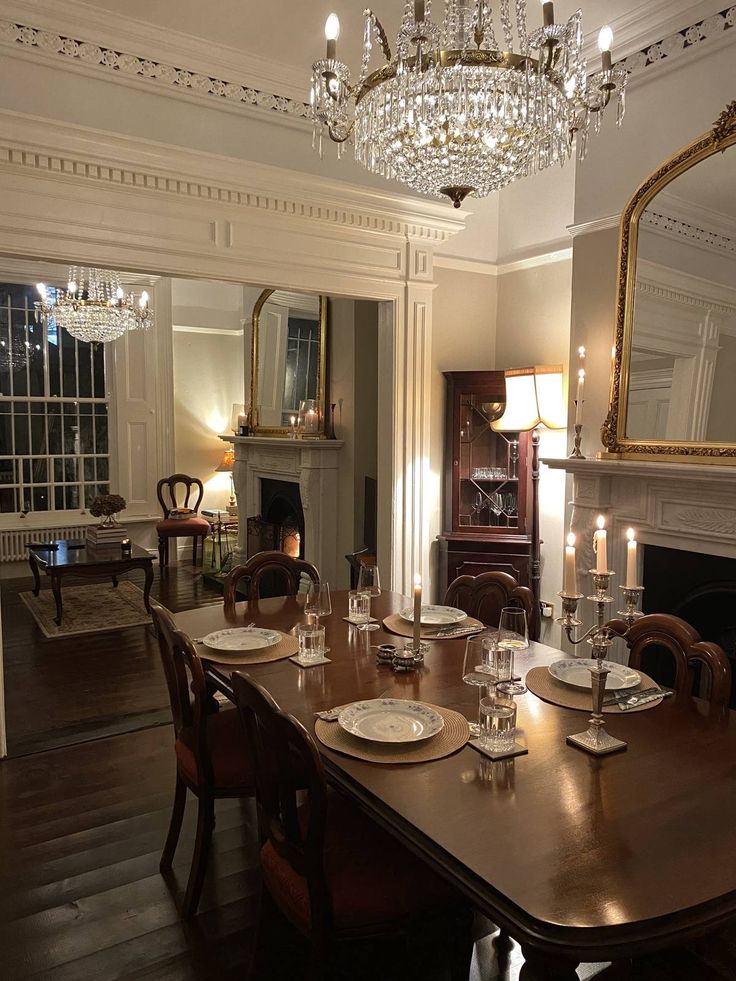 the dining room table is set with place settings for six people and candles are lit