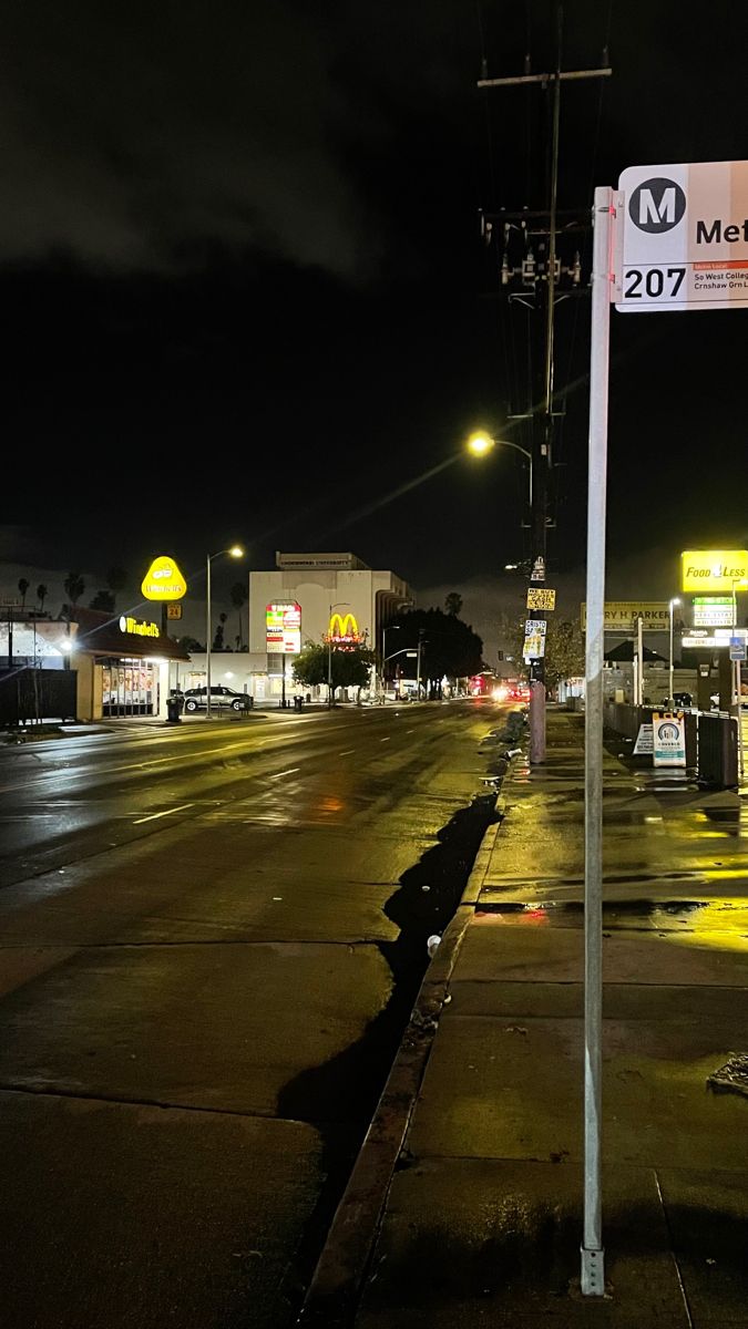 an empty street at night with the lights on