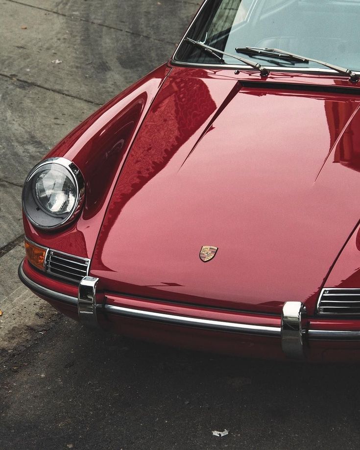 a red porsche sits parked on the street