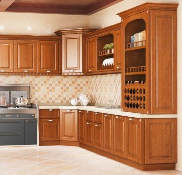 a large kitchen with wooden cabinets and tile flooring, along with a stainless steel stove top oven