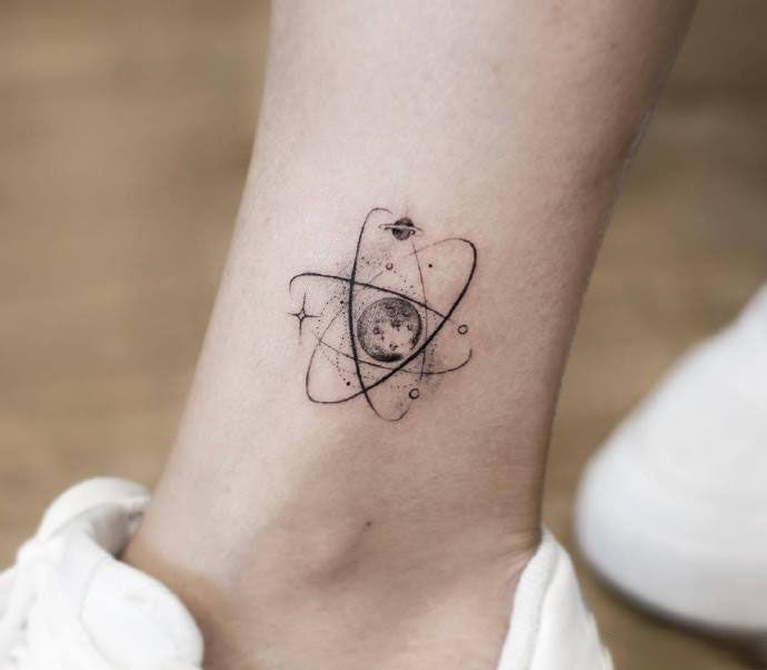 a small tattoo on the ankle of a woman's foot, with an object in the middle