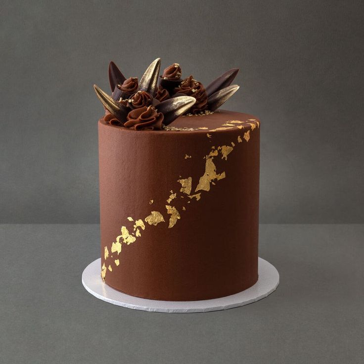 a chocolate cake with gold leaf decoration on top