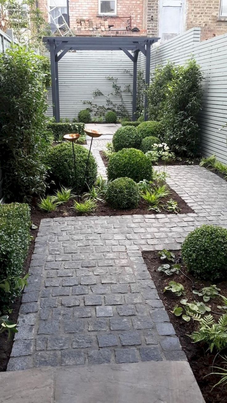 a brick walkway in the middle of a garden