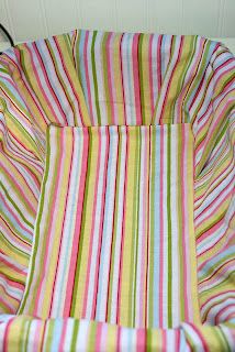 a baby's chair that is covered in colorful striped fabric