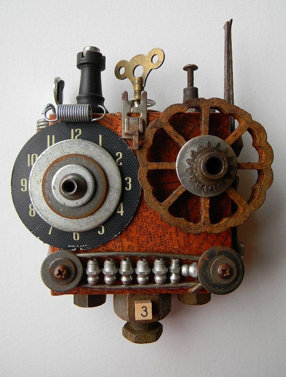 a clock made out of assorted parts on a white wall with the number three