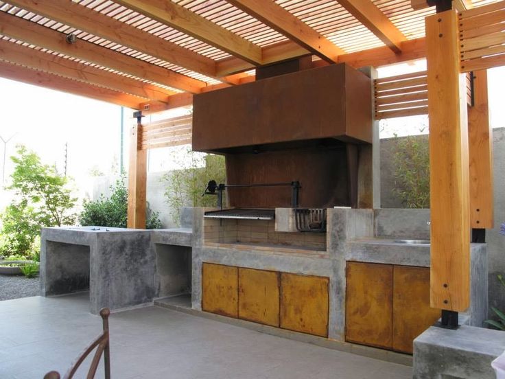 an outdoor kitchen with granite counter tops and grilling area in the middle of it