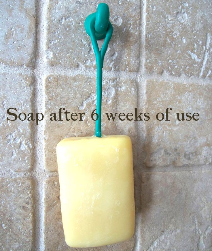 a soap dispenser with a green toothbrush in it on a tile wall