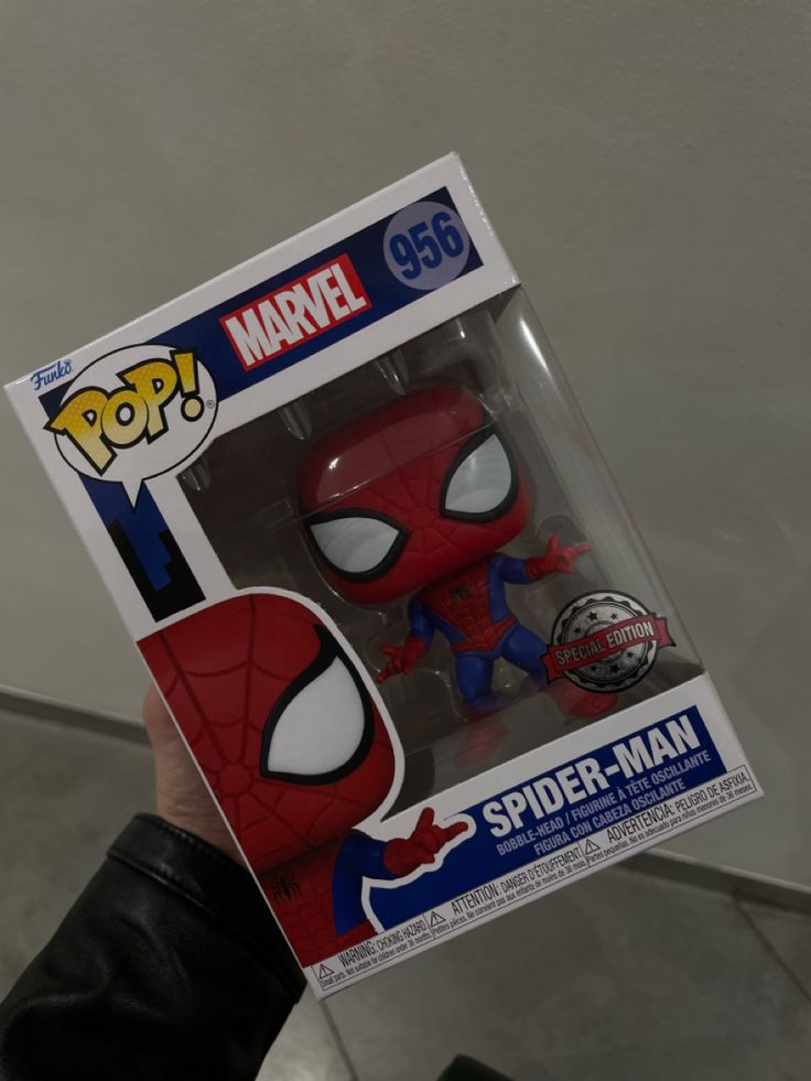 a person holding up a spider - man pop vinyl figure