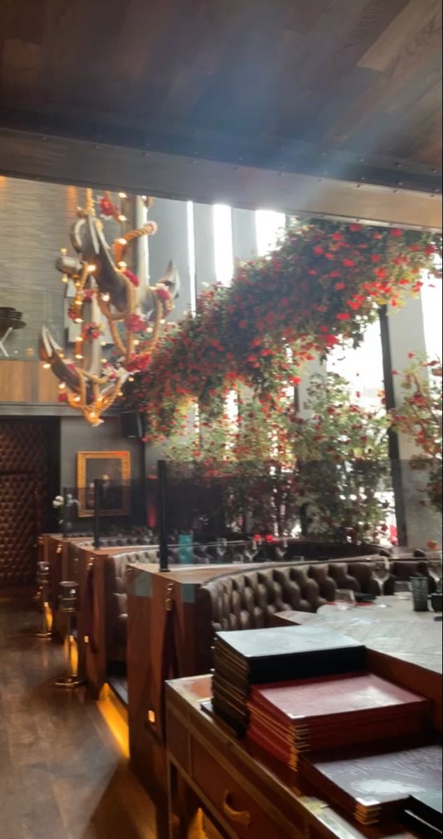 the interior of a restaurant with lots of tables and chairs in front of a chandelier