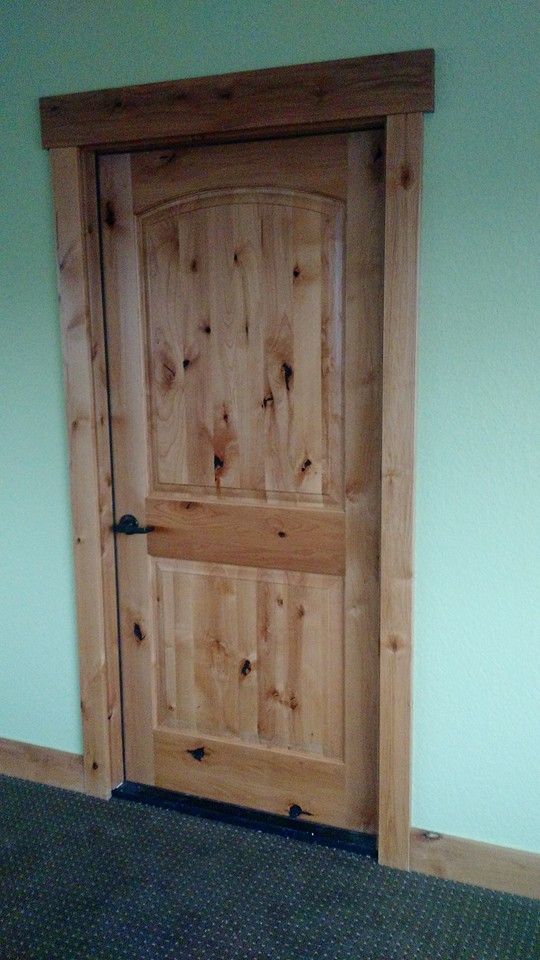 a wooden door in the corner of a room with carpet on the floor and green walls