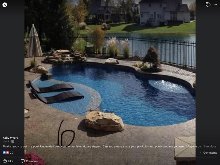 a backyard with a swimming pool surrounded by rocks and water features an outdoor lounge area