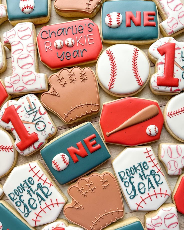 decorated cookies are arranged in the shape of baseballs and mitts for one year