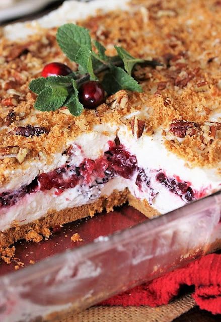 a close up of a dessert with cranberries and other toppings on it