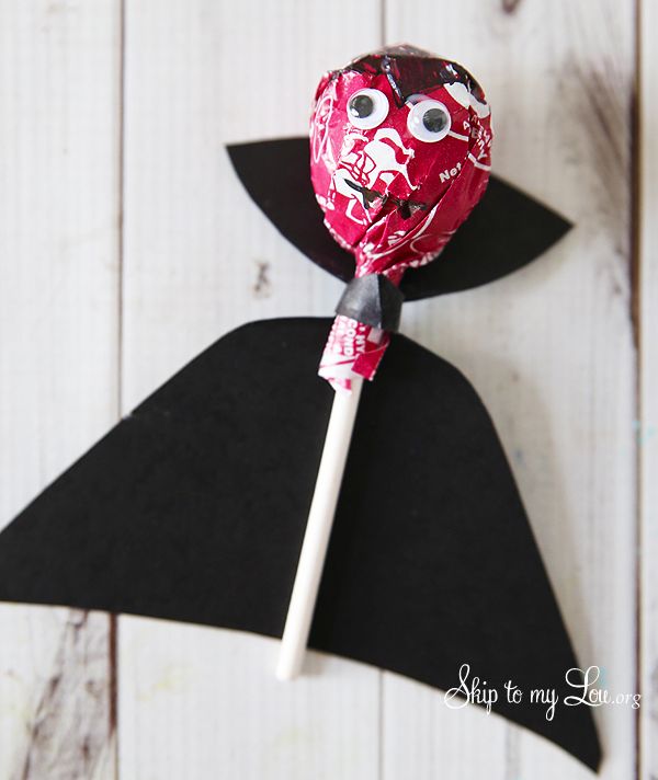 a candy bar wrapped in black paper with a red and white stick sticking out of it