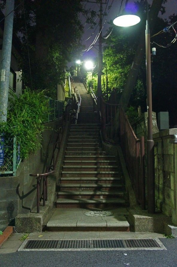 the stairs lead up to the street at night