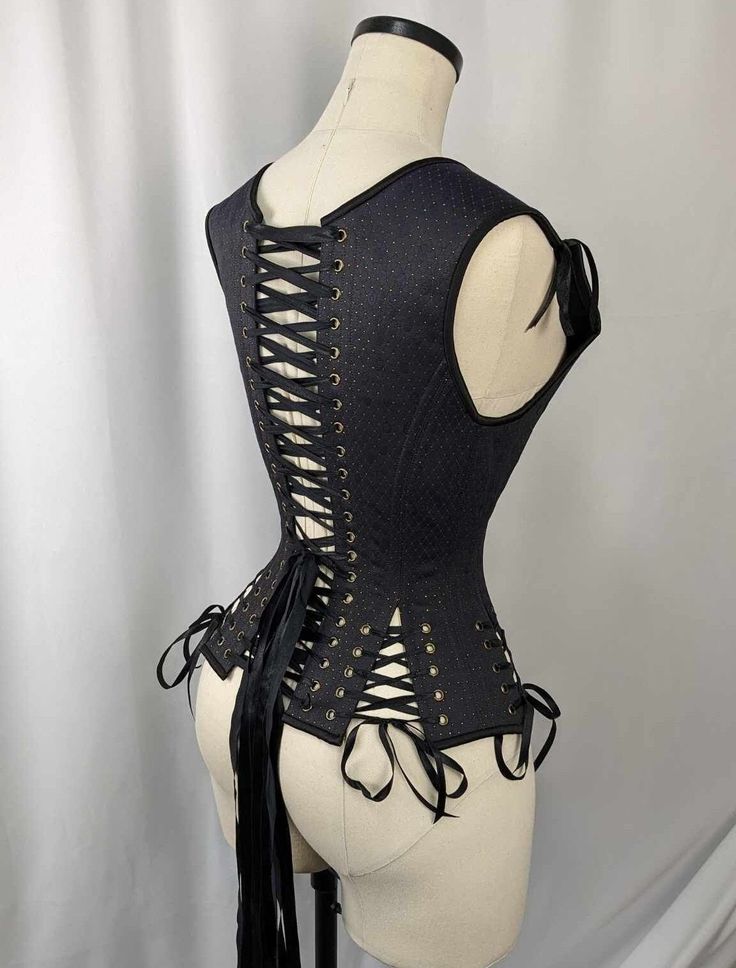 Navy, Black, and Gold Androgynous Low Curve Corset Vest This listing is for a made to order corset made using our custom pattern! Constructed from a stunning Navy on Black Jacquard with gold diamond accents and a cotton twill liner, this corset is perfect for victorians, goths, and the renaissance faire alike.  This corset is made of a Black and Navy Jacquard with a Gold Diamond Pattern, tied together with Black binding,  Black stitching, Black laces and bronze colored hardware. Our 435 Pattern is a low curve corset vest that is perfect for all day wearers, newer corset wearers as well as customers who are looking for a flattering shape on many different body styles! Adjustable shoulders and hip ties in the front and back mean that this corset can be tweaked for tons of different body shap Fitted Gothic Bodice For Wedding, Gothic Fitted Bodice For Wedding, Gothic Underbust Fitted Corset Dress, Gothic Fitted Underbust Corset Dress, Fitted Underbust Gothic Corset Dress, Wedding Black Fitted Corset Belt, Fitted Gothic Corset Dress With Corset Back, Gothic Fitted Corset Dress With Corset Back, Elegant Fitted Corset Belt For Costume Party