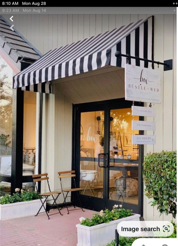 a storefront with black and white awnings on it's front door