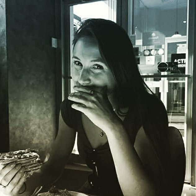 a woman sitting at a table eating pizza