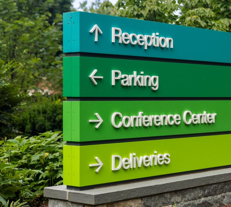 a green and white sign that says reception, parking, conference center, deliverres