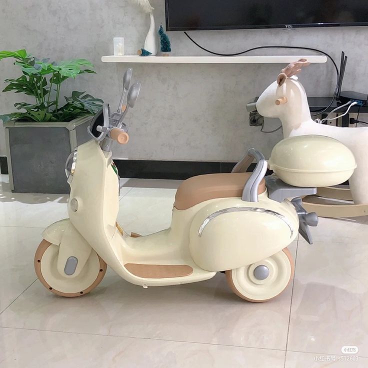 a toy scooter with a unicorn on the back and a television in the background