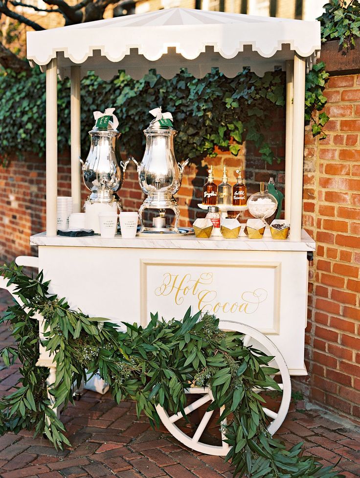 an old fashioned ice cream cart is decorated with greenery