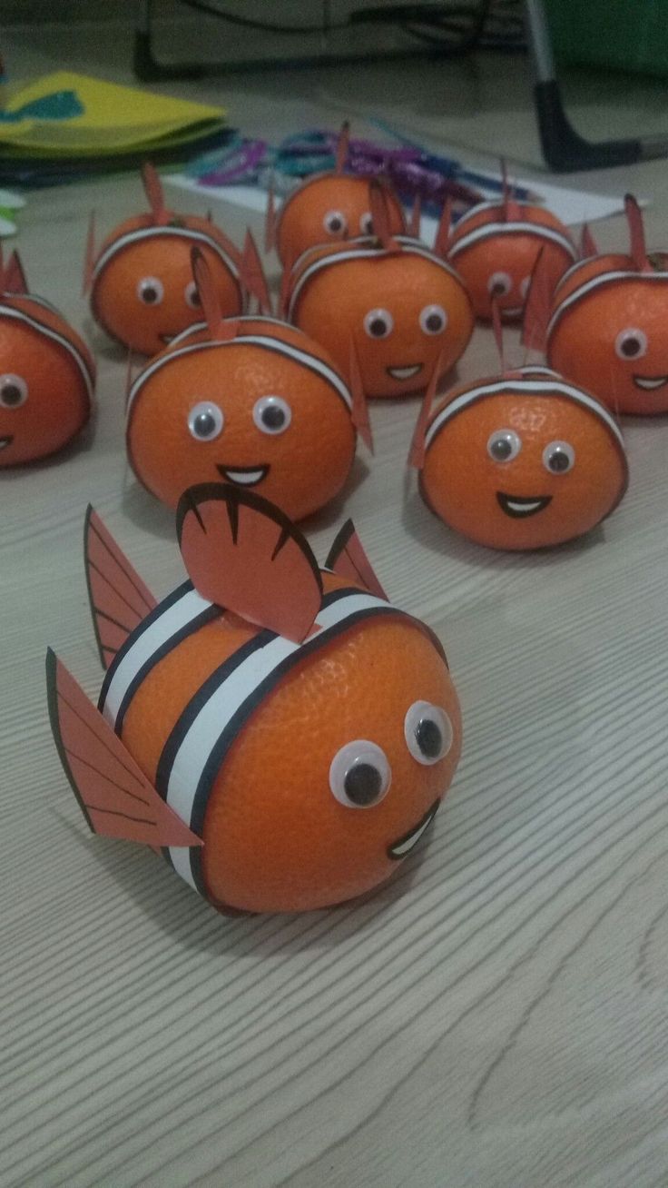 many orange clown fish are on the table with toothpicks in front of them