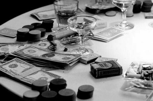 a table topped with lots of money and wine glasses