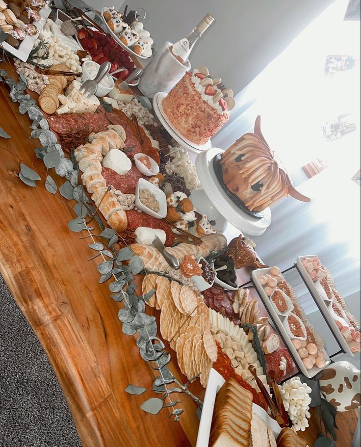 a table filled with lots of food on top of a hard wood floor next to a window