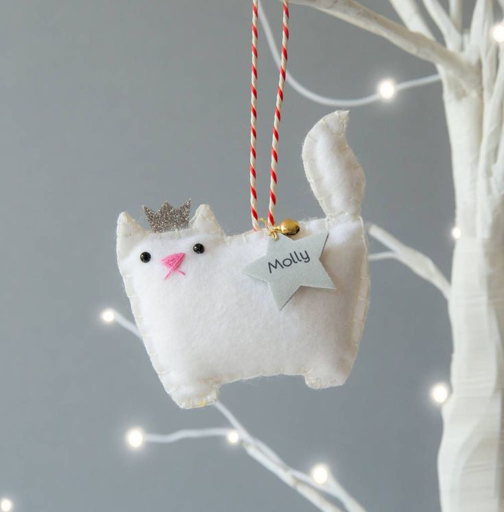 a white cat ornament hanging from a tree