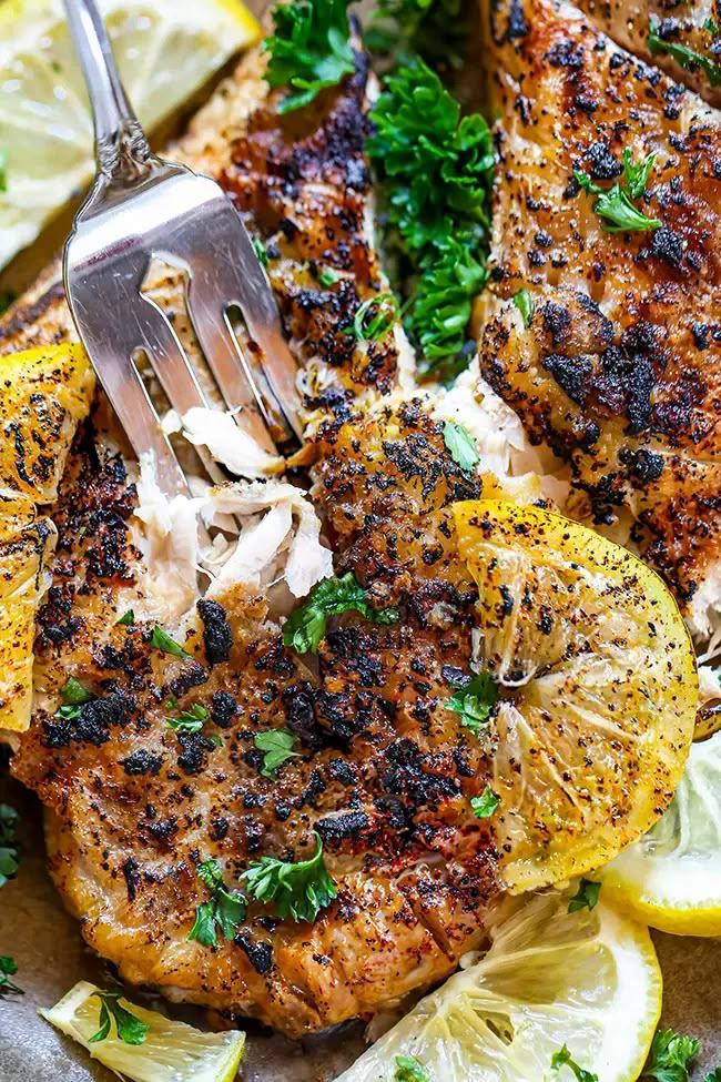 grilled chicken with lemons and parsley on a plate