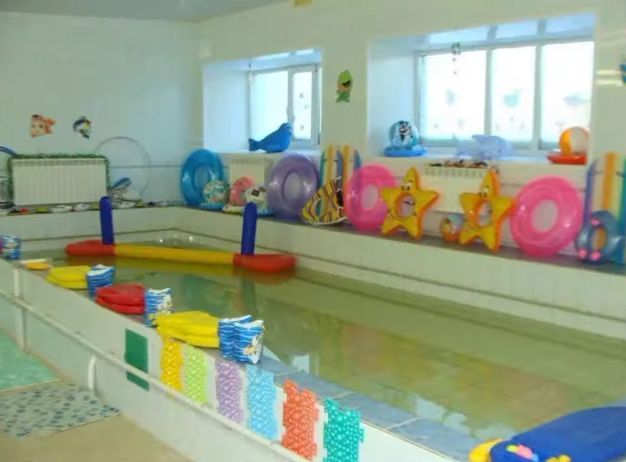 an indoor swimming pool with toys in it