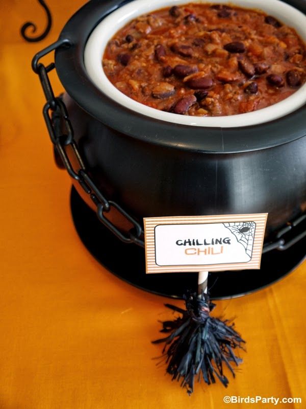 a bowl of chili sitting on top of a table next to a sign that says calling