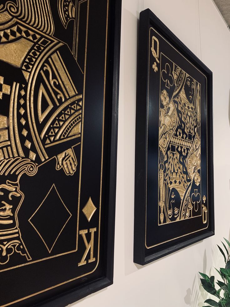 two black and gold playing cards hanging on the wall