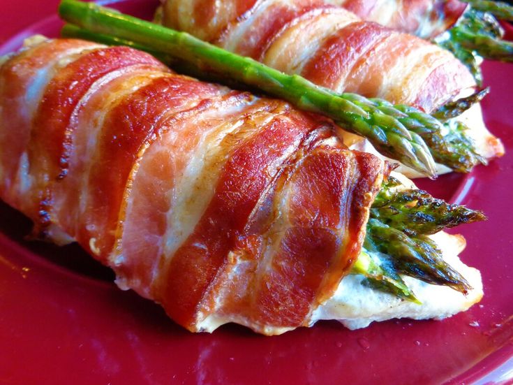 bacon wrapped asparagus on a red plate