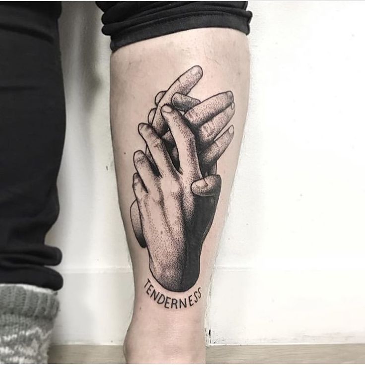 a person with a black and white tattoo on their leg holding the hands of another person