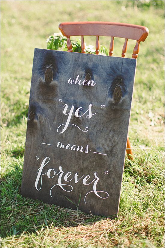 a sign that says when yes means forever sitting in the grass next to a wooden chair