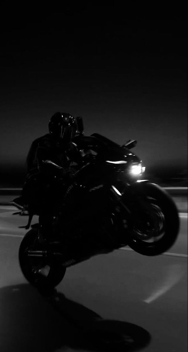 a person riding a motorcycle in the dark