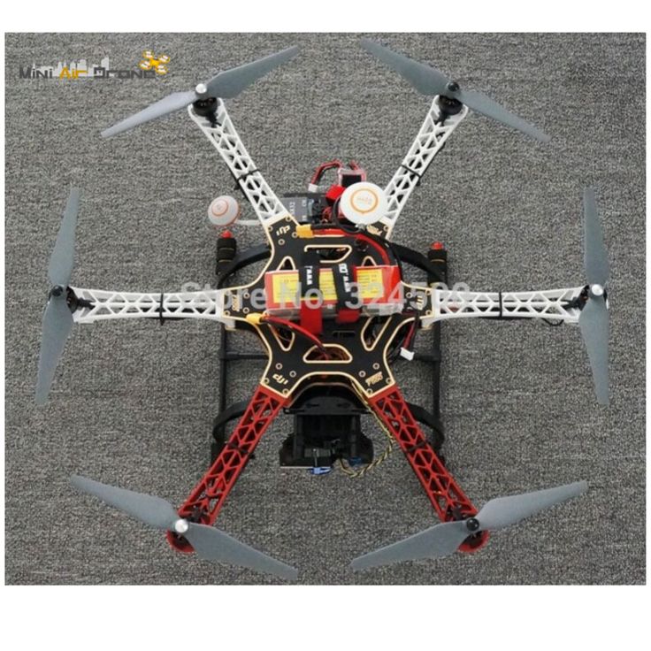 a red and black remote controlled flying device on top of a gray carpeted floor