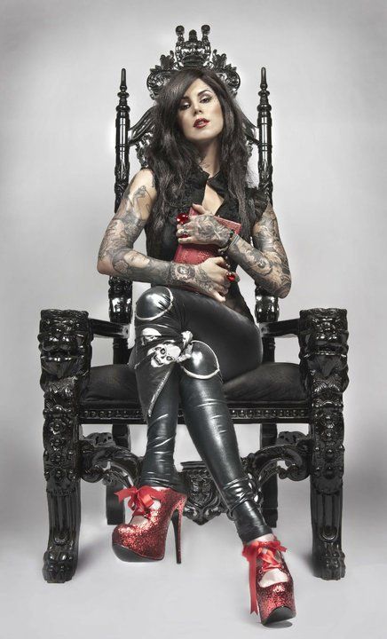 a woman with tattoos sitting on a throne