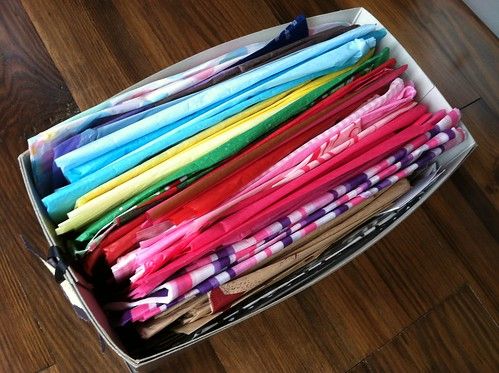 an open suitcase filled with lots of different colored clothes on top of a wooden floor