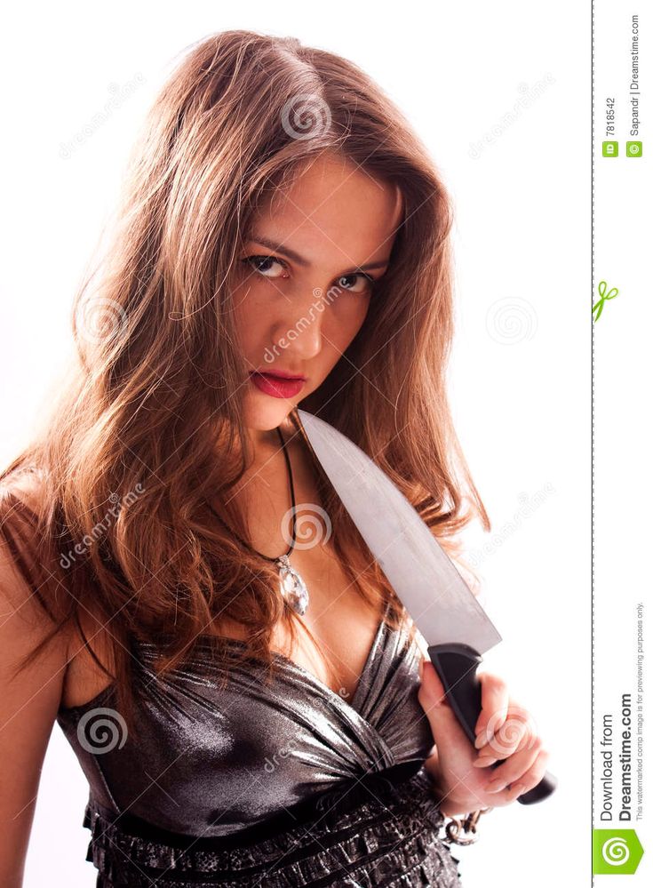 a beautiful young woman holding a knife in her hand and looking at the camera with an intense