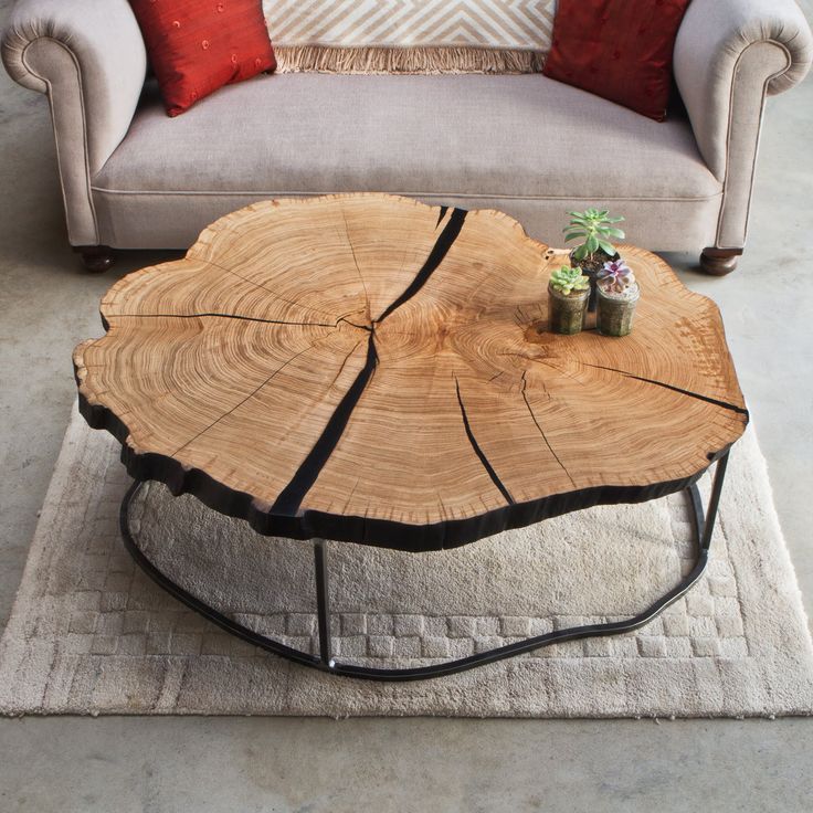 a living room with a couch and table made out of tree slices on the floor