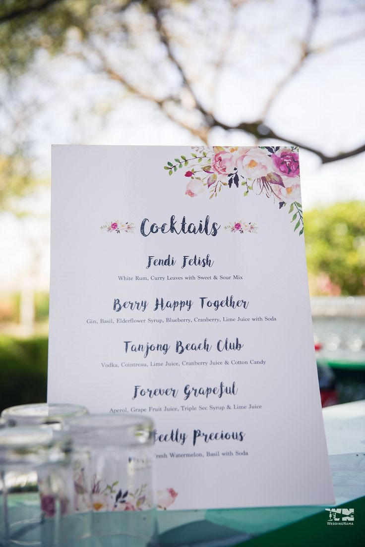 a menu is set up on a table with jars and glasses in front of it