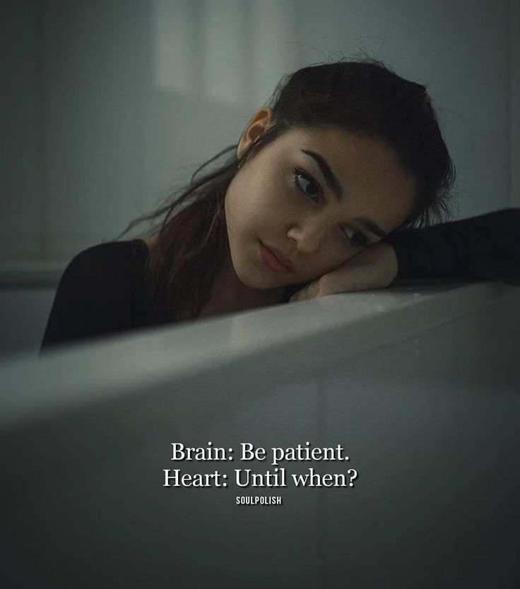 a woman leaning on the edge of a bed with her head resting on her hand