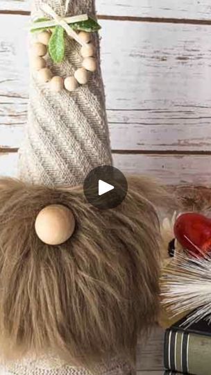 a stuffed animal sitting next to some books and a vase with beads on it's head