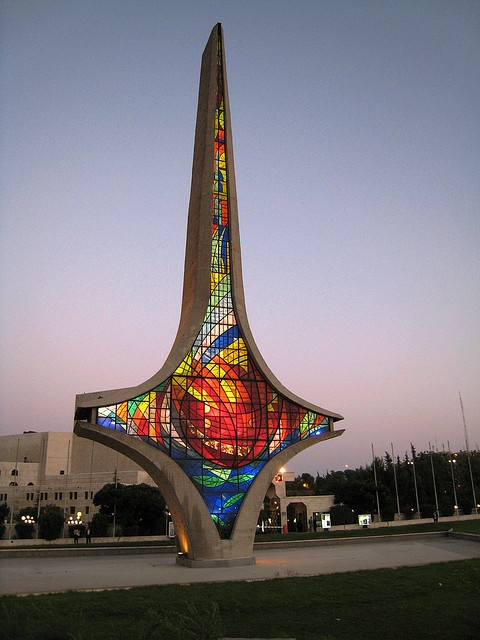 a very tall building with a colorful stained glass window on it's front side